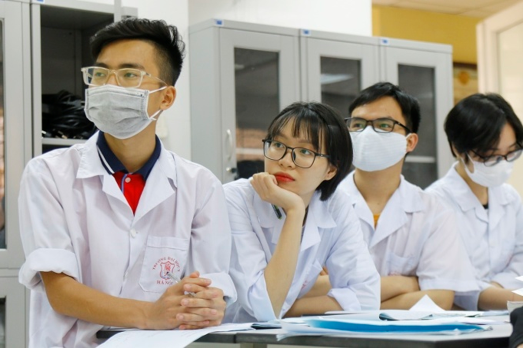 A group of people wearing white lab coats and face masks

Description automatically generated